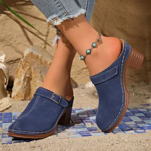 Detailweergave van retro blauwe dichte muiltjes met hoge hak en gesp op het zand