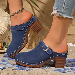 Zijaanzicht van donkerblauwe mules met hoge hak, retro gesp en witte stiksels