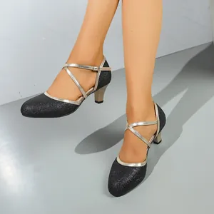 Detailed view of black glitter high-heeled dance shoes with golden cross straps for Waltz