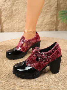Primer plano detallado de zapatos de tacón bloque rojo y negro con estampado serpiente