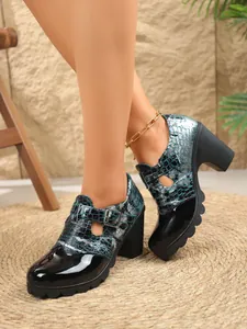 Detalle de zapatos de tacón grueso de charol para mujer con estampado de cocodrilo