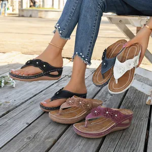 Vista detallada de chanclas de cuña para mujer con adornos de flores en varios colores