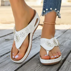 Detalle de sandalias blancas con plataforma y cuña con flores y patrones cortados por láser