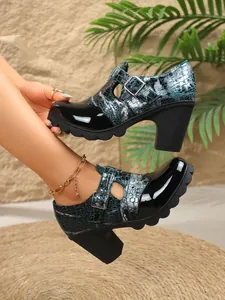 Primer plano de zapatos de tacón grueso para mujer con estampado de cocodrilo y charol