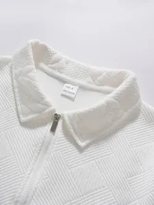 Detail of white textured half-zip polo shirt showing collar and 100% polyester label.