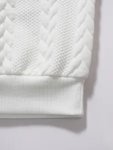 Detailed view of white jacquard textured fabric and ribbed hem on casual men's polo shirt
