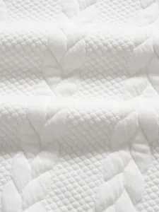 Macro view of white jacquard knit fabric showing the detailed texture and weaving pattern