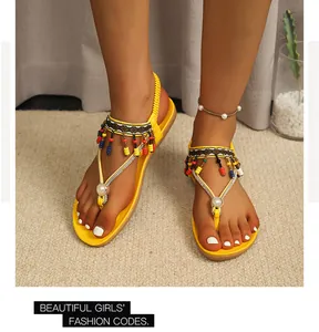 Stylish yellow Bohemian beaded thong sandals with rhinestones and elastic strap for beach.