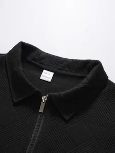 Close-up of men's black jacquard polo shirt collar with half-zip and size tag