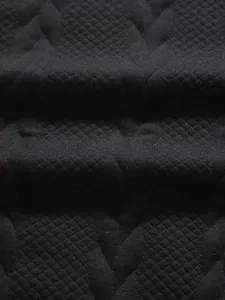 Detailed close-up showing the textured black jacquard fabric of a men's polo shirt