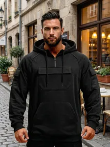 Men's black cargo sweatshirt with half-zip design and multiple utility pockets on a street
