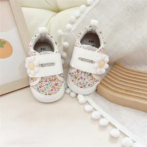 Detail view of floral baby walking shoes with 3D daisy flower on velcro strap