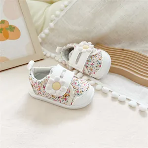 Close-up view of floral print baby walking shoes featuring a decorative white daisy strap