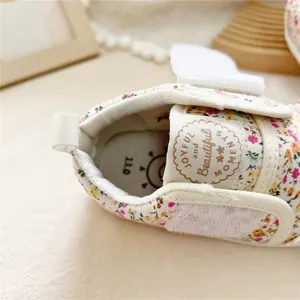 Macro detail view of a floral baby walking shoe featuring soft sole and velcro strap