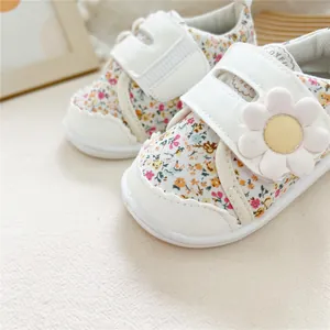 Close-up of floral print baby walking shoes with decorative flower and velcro strap.