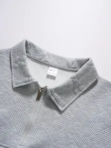 Close-up view of grey quilted texture and half-zip collar on casual men's polo shirt