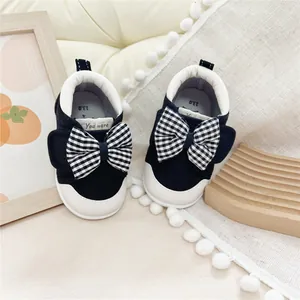 Detailed view of forest-style baby walking shoes with checkered bow design