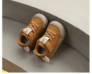 Close-up of mustard yellow toddler walking shoes with protective toe caps and velcro straps