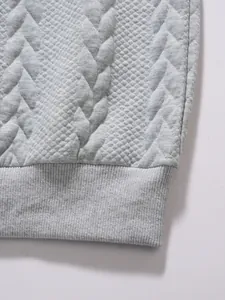 Detailed macro shot of grey men's polo shirt featuring jacquard texture and ribbed hemline
