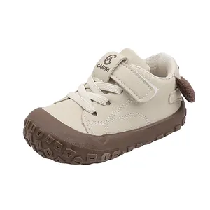 Side view of beige leather baby walking shoe with brown rubber sole and cute ear detail