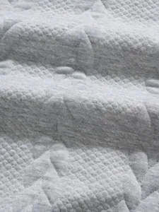 Macro view of grey men's polo shirt fabric showing premium jacquard texture and star motifs