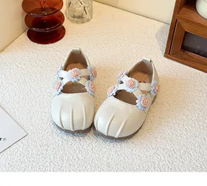 Detailansicht von cremefarbenen Mary Jane Schuhen für Kinder mit bunten Blumenverzierungen