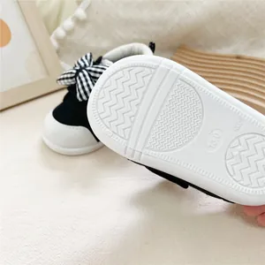 Detail view of anti-slip rubber sole on baby walker shoes with checkered bow