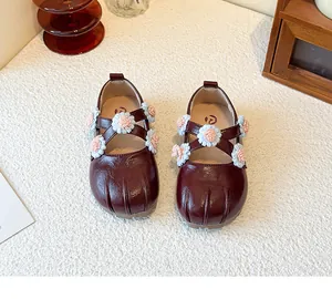 Nahaufnahme burgunderfarbene Mädchen Mary Janes mit gestrickten Blumen