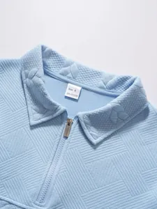 Close-up detail of light blue men's casual polo shirt featuring jacquard texture and half-zip