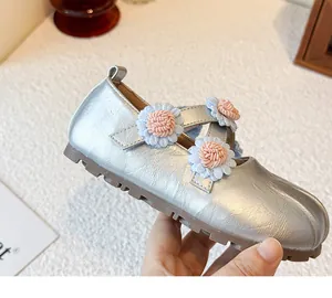 Detaillierte Makroansicht silberner Mary Jane Mädchenschuhe mit 3D-Blumenverzierung