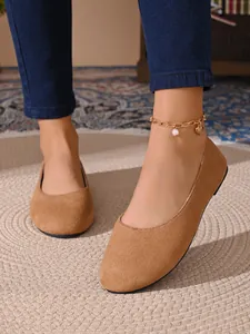 Dettaglio ballerine donna in camoscio color cammello con cavigliera elegante.