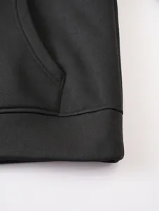 Detailed close-up showing the premium fabric texture and stitching of a black hoodie.