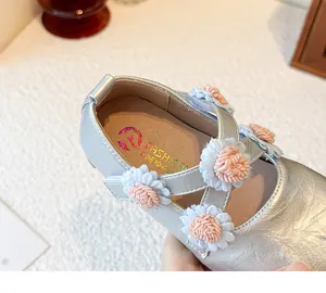 Detail von silbernen Mary-Jane-Schuhen für Mädchen mit süßen rosa und blauen Blumen