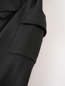 Macro close-up detail of the durable cargo pocket on a black fleece hooded sweatshirt jacket