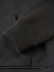 Macro detail shot showing the ribbed cuff and pocket of a black casual hooded sweatshirt