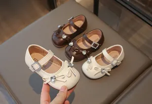 Nahaufnahme von eleganten Prinzessinnenschuhen für Mädchen mit Strassschleife und Schnallen