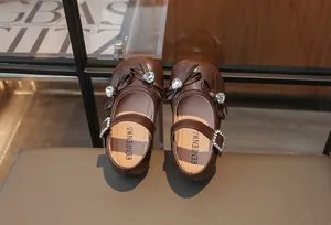 Detailansicht brauner Mädchen-Prinzessinenschuhe mit Strass-Schleifenakzenten
