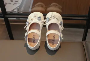 Detailansicht der cremefarbenen Mädchen-Ballerinas mit Strass-Herzschleifen-Deko