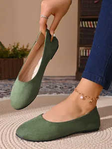 Primo piano di ballerine in camoscio verde a punta tonda con design slip-on