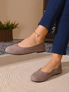 Primo piano dettagliato delle eleganti ballerine scamosciate marroni da donna.