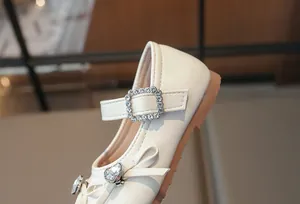 Nahaufnahme eines Mädchen-Prinzessin-Schuhs mit glitzernder Strass-Schleife und Herz.