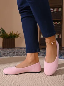 Primo piano di ballerine rosa in camoscio a punta tonda dal design confortevole