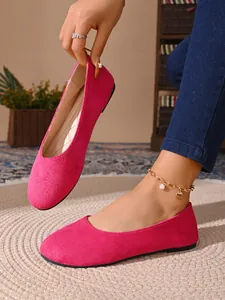 Dettaglio ravvicinato di eleganti ballerine in camoscio fucsia per donne di classe
