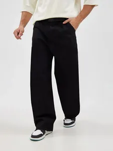 Full-length view of men's loose black oversized straight-leg denim jeans on a model.
