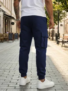 Vista trasera de pantalones cargo azul marino para hombre con bolsillos y puños ajustados.