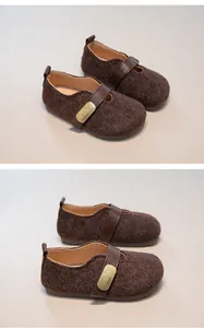 Detail of children's brown wool Mary Jane shoes with leather strap and metal buckle