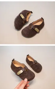Detailed view of brown wool felt retro children's shoes with leather strap buckle