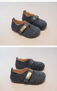 Close-up detail of children's retro gray tweed shoes featuring a stylish gold metal buckle