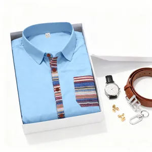 Close-up of light blue men's shirt with striped pocket in a gift box with accessories.