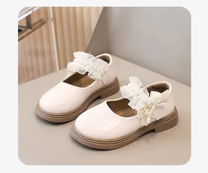 Dettaglio di scarpe da principessa bianche per bambine con pizzo, perle e suola morbida